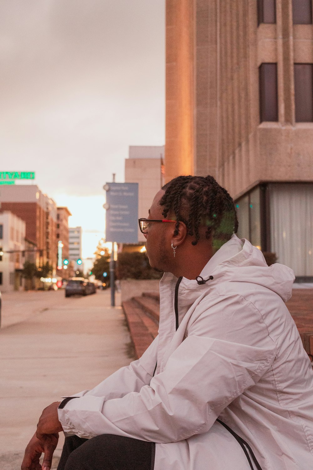 a man sitting on a bench in front of a building