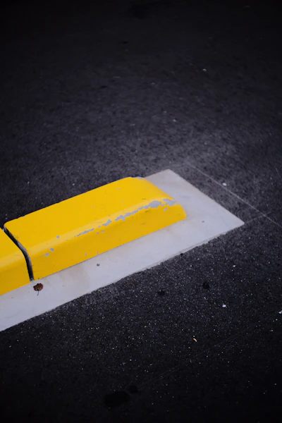 a yellow bench sitting on the side of a road