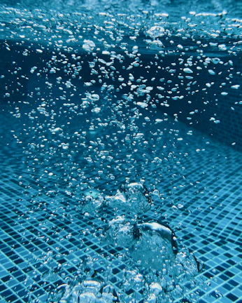 Close-up of sparkling clean pool water with bubbles rising to the surface.