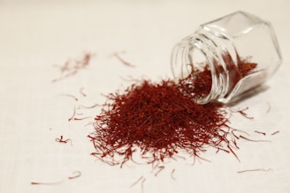 a glass jar filled with red stuff on top of a table