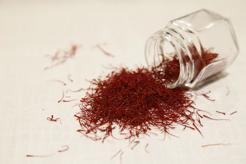 Glass jar of saffron threads on a pale surface