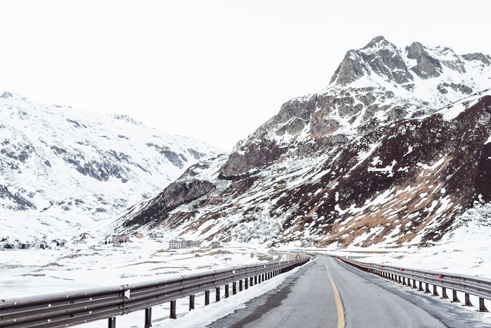 a snowy road with a mountain in the background