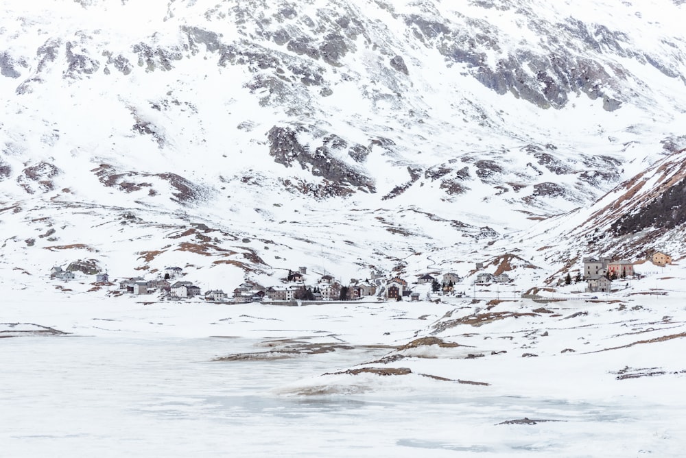 a snow covered mountain with a village in the foreground