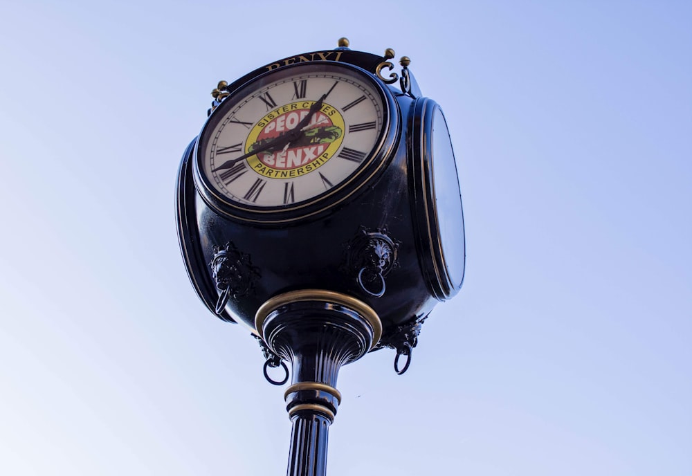 a clock on a pole with a sky background