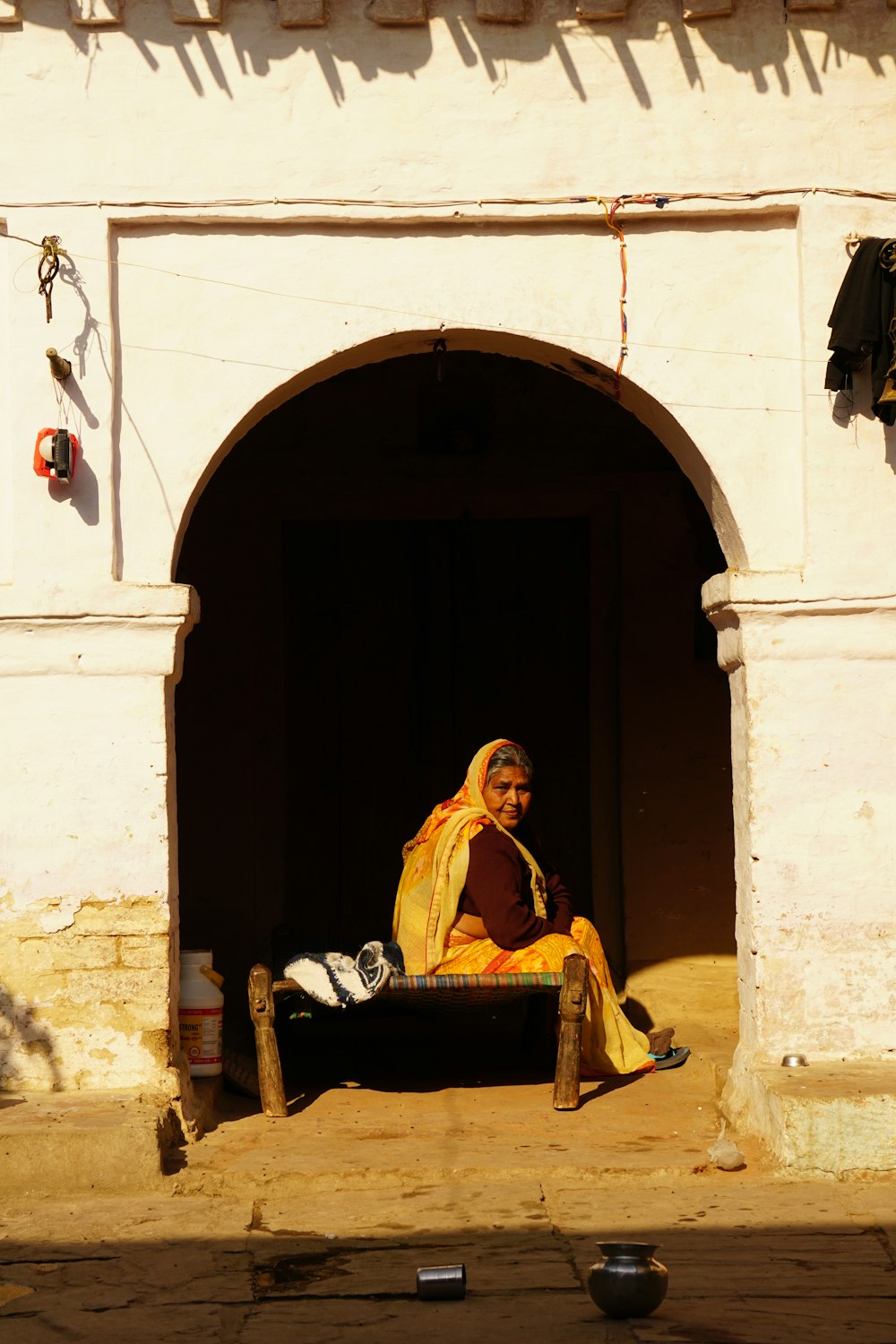 a woman sitting on a bench in a doorway