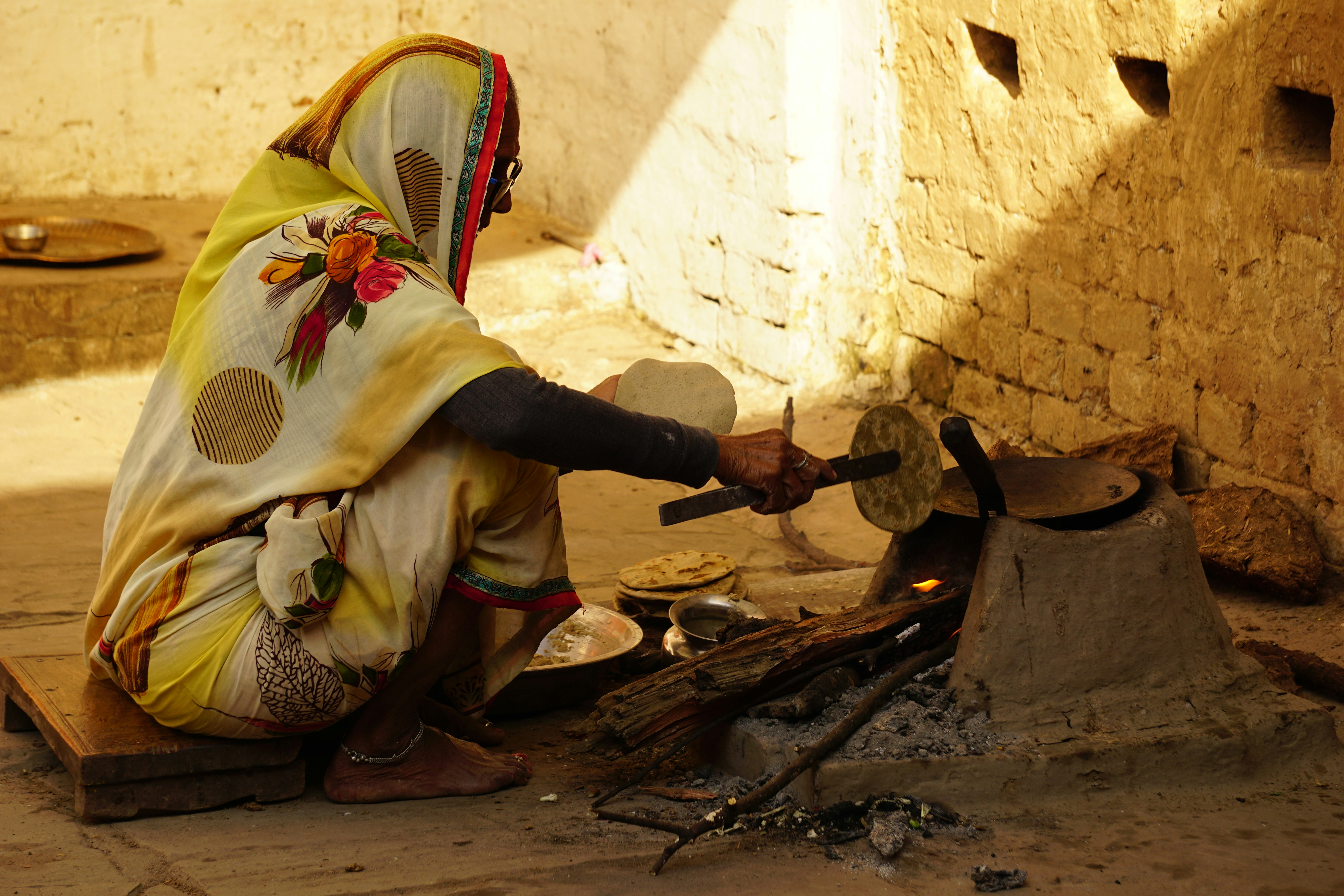 Indian woman cooking in yellow sari