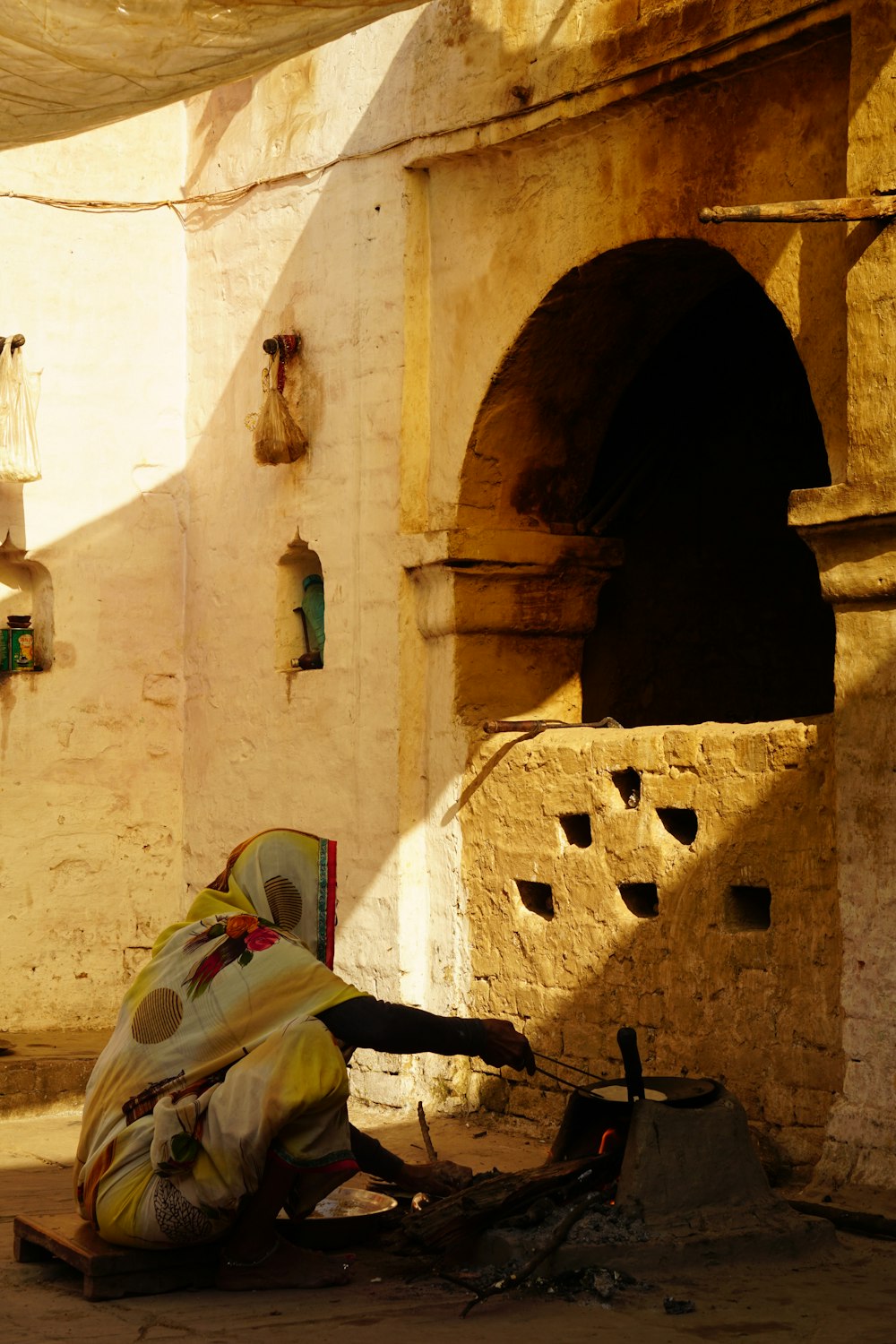 a woman sitting on the ground in front of a building