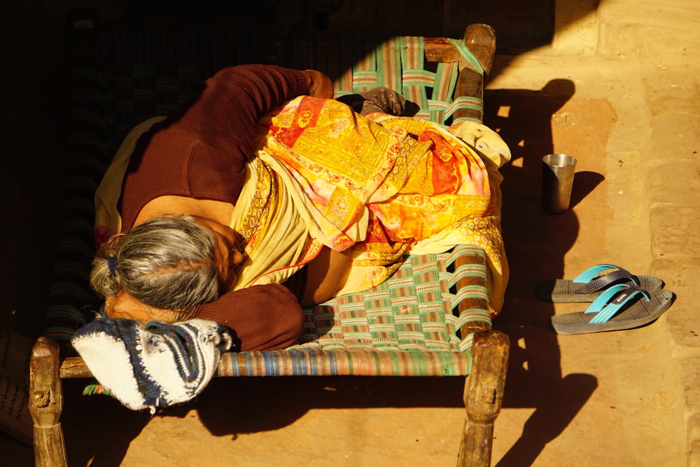 a man sleeping on a chair with his head on his hands