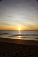 A stunning sunset over a calm ocean beach.