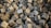 A large pile of rough, textured concrete blocks arranged haphazardly, creating a chaotic and rugged appearance. The blocks are predominantly cubic in shape, with uneven, worn surfaces reflecting various shades of gray.