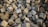 A large pile of rough, textured concrete blocks arranged haphazardly, creating a chaotic and rugged appearance. The blocks are predominantly cubic in shape, with uneven, worn surfaces reflecting various shades of gray.