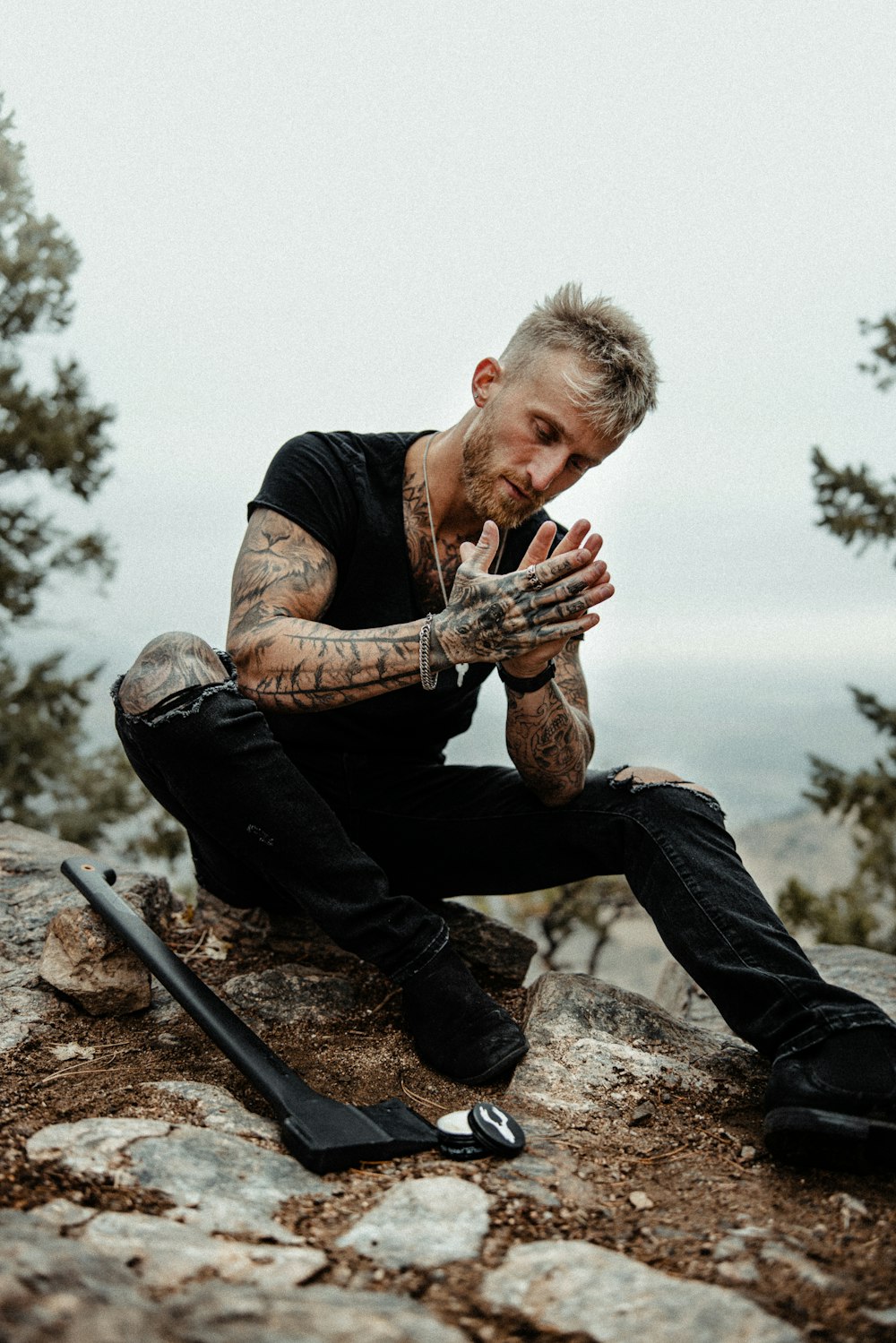 a man sitting on top of a rock next to a pair of skis