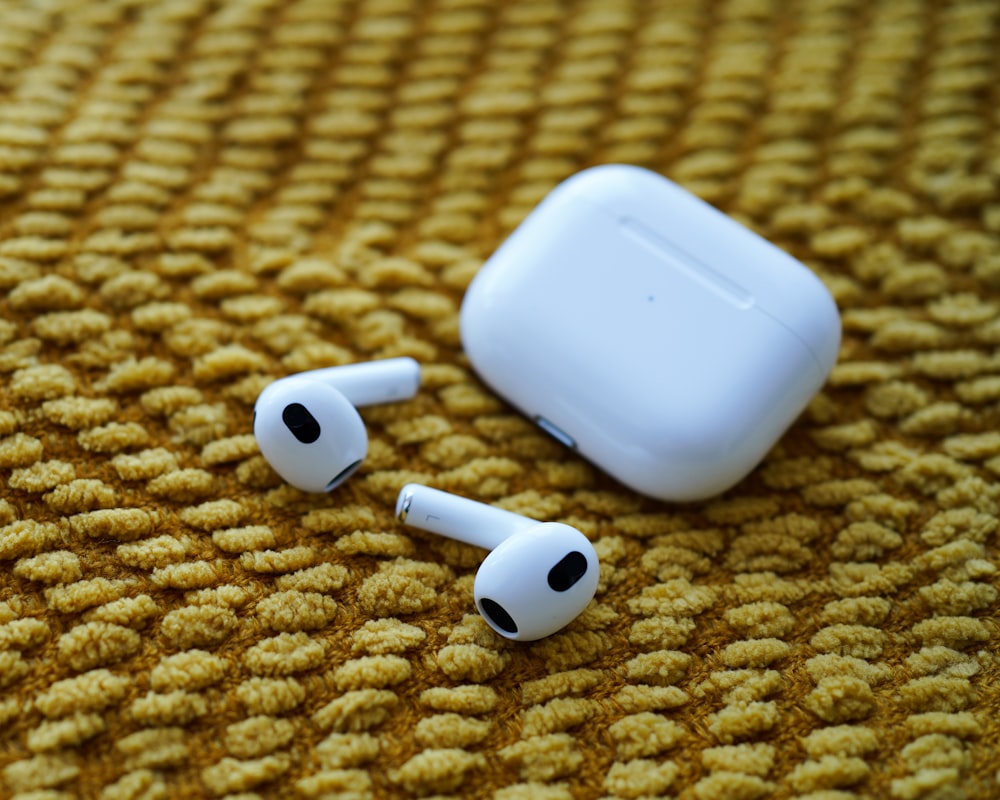 a pair of ear buds sitting on top of a carpet