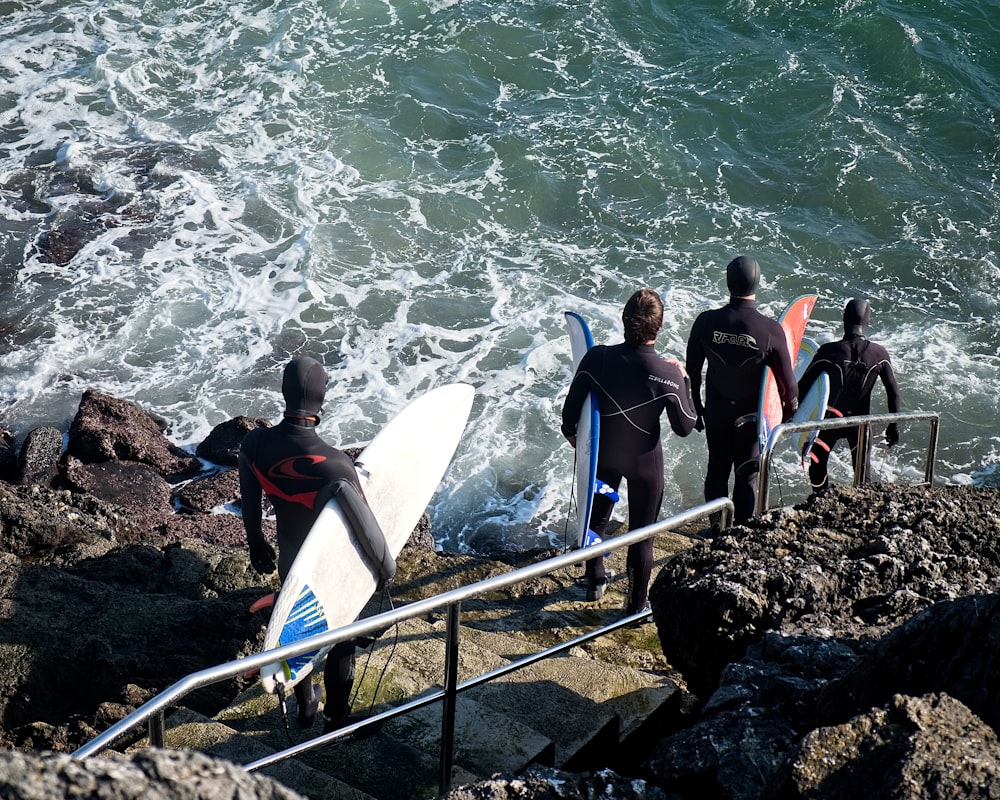 a group of surfers walking up to the ocean