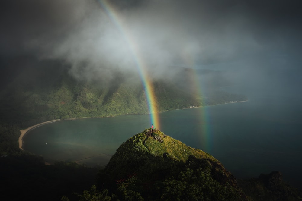 um arco-íris duplo é visto sobre o oceano