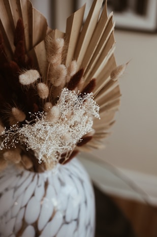 Artful arrangement of dried flowers and pampas stems on a crisp white surface embodying subtle elegance.