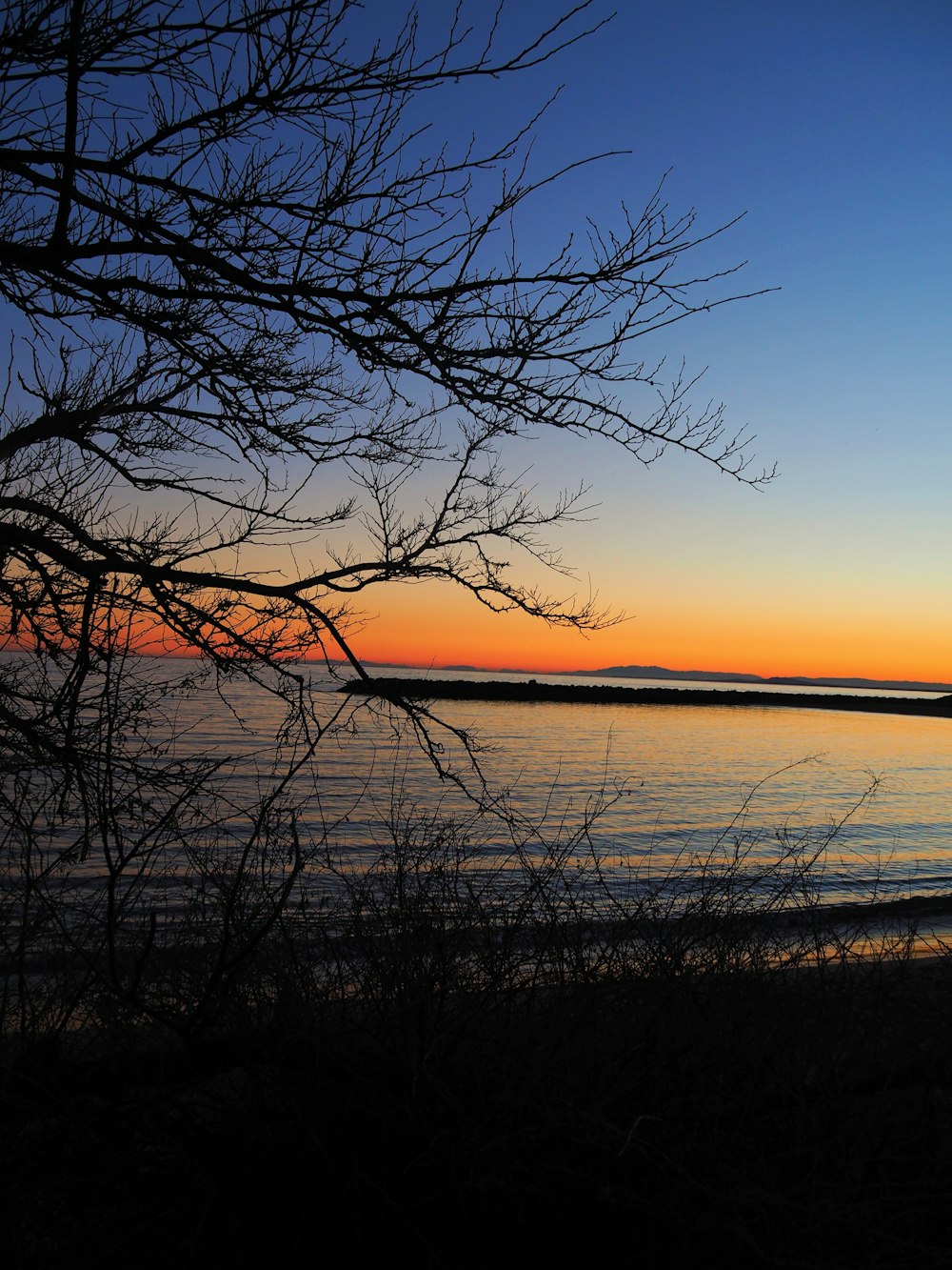 the sun is setting over a body of water