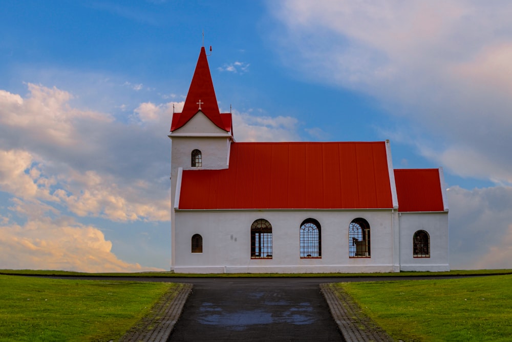 uma igreja branca com um telhado vermelho em um dia nublado