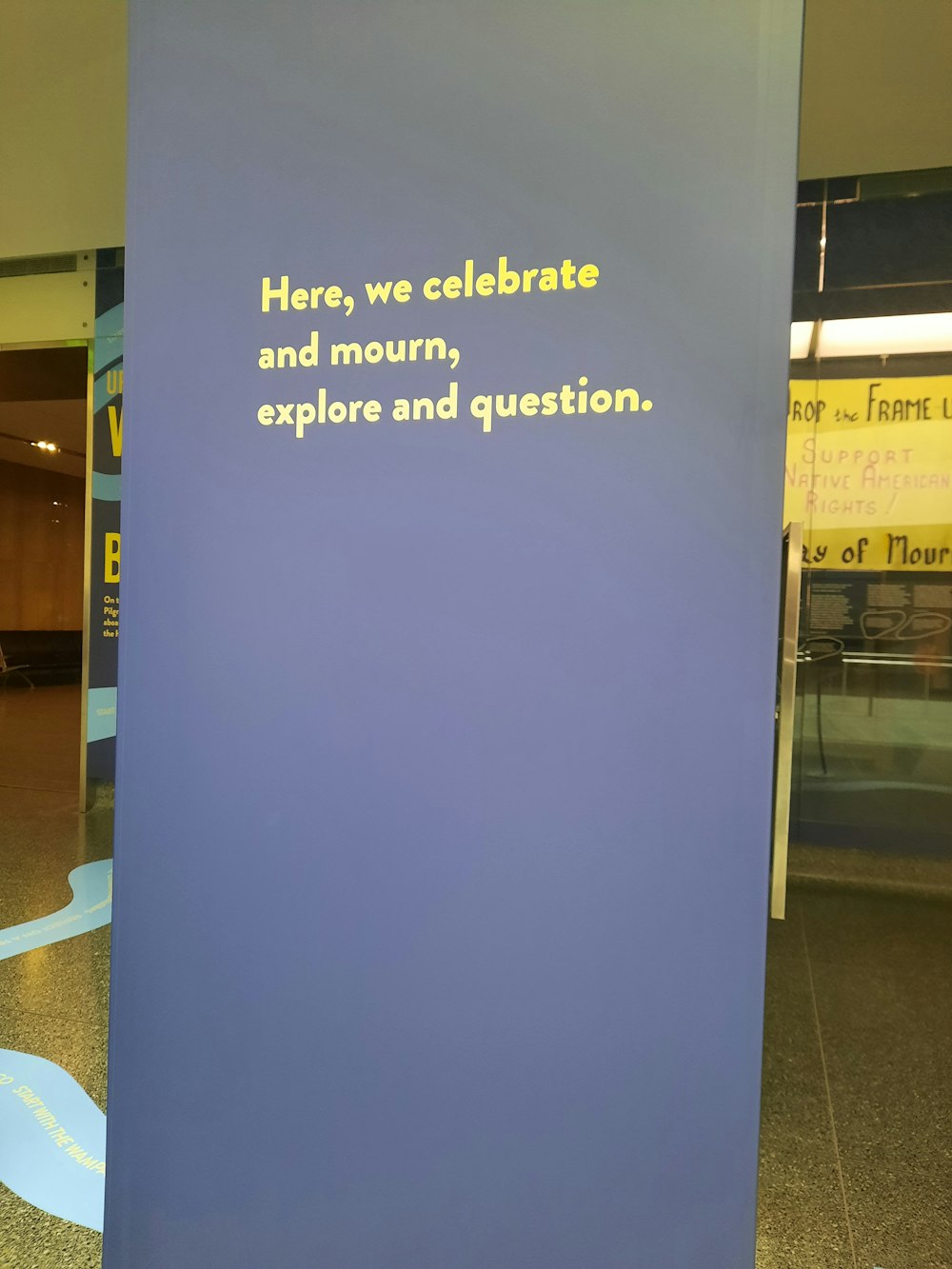 a blue sign that says here, we celebrate and mount, explore and question