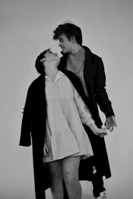 A couple dressed in coordinated noirwolf fashion outfits, sharing a joyful moment.