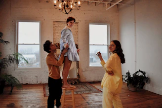 A bright, welcoming home environment where a support worker assists a smiling participant.