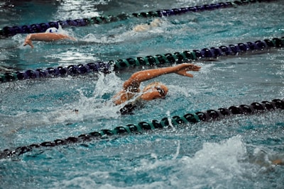 Group of enthusiastic swimmers training together under the guidance of a coach.