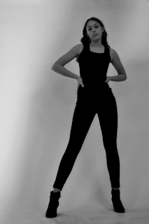 Black and white editorial shot of a model in Rusbelsoon pants and boots, standing strong.