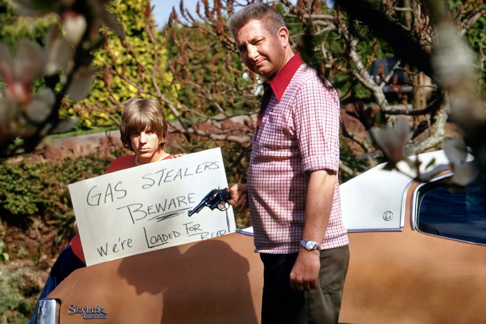 Ein Mann steht neben einem Jungen, der ein Schild hält