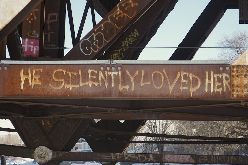 a rusted metal sign that says we silently loved her