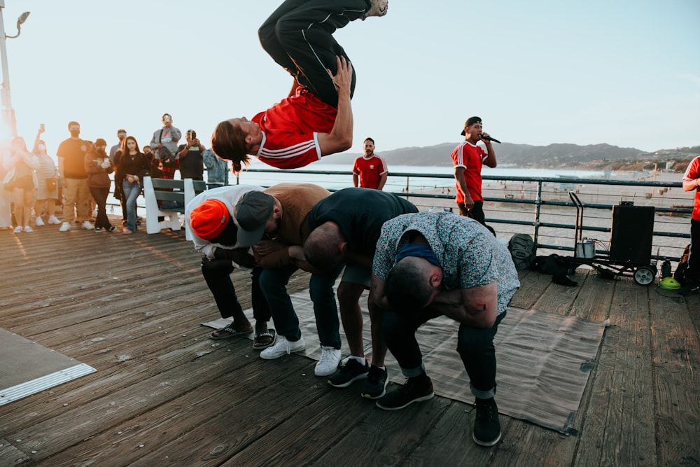 a group of men standing on top of a wooden pier