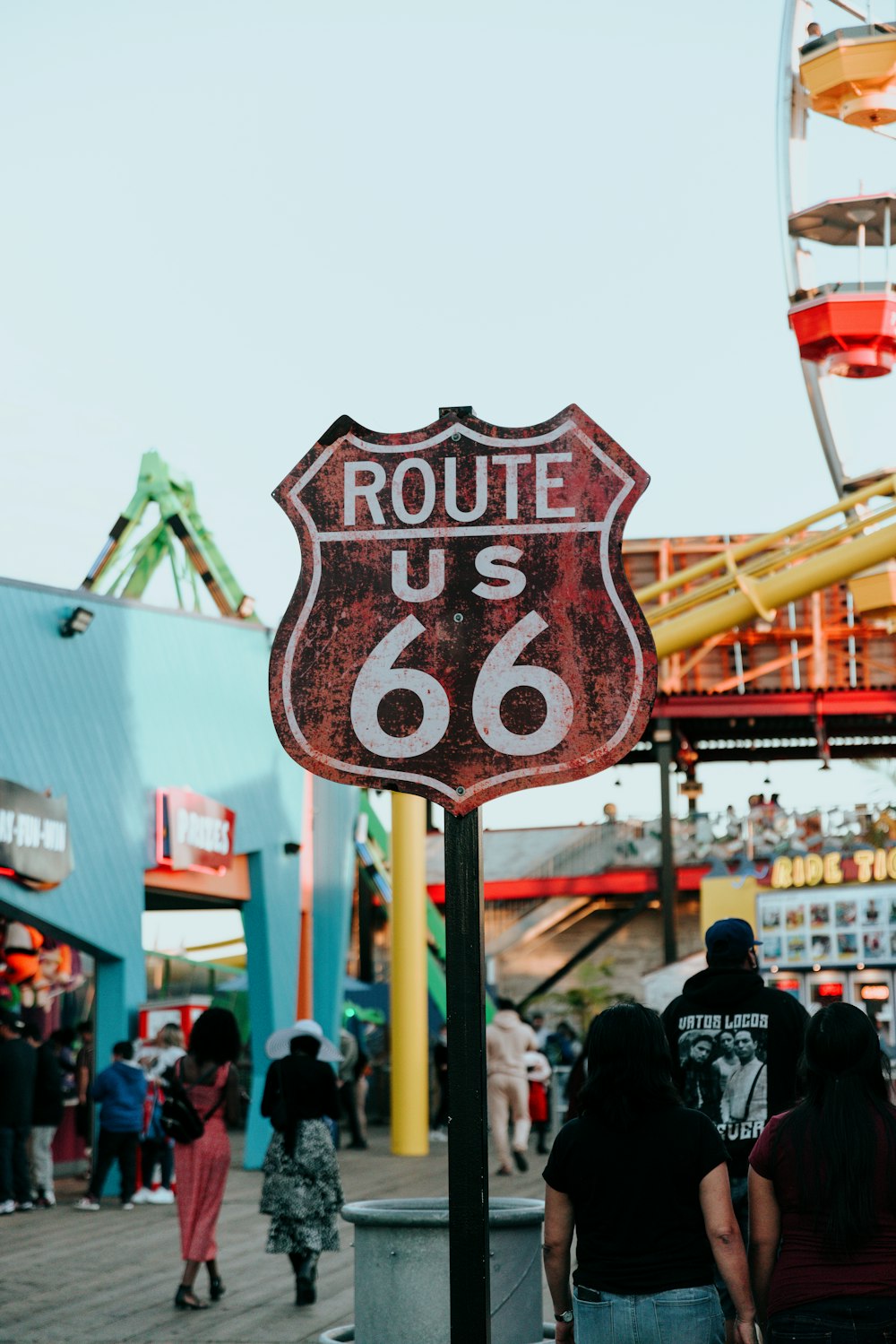 a red route 66 sign sitting on the side of a road