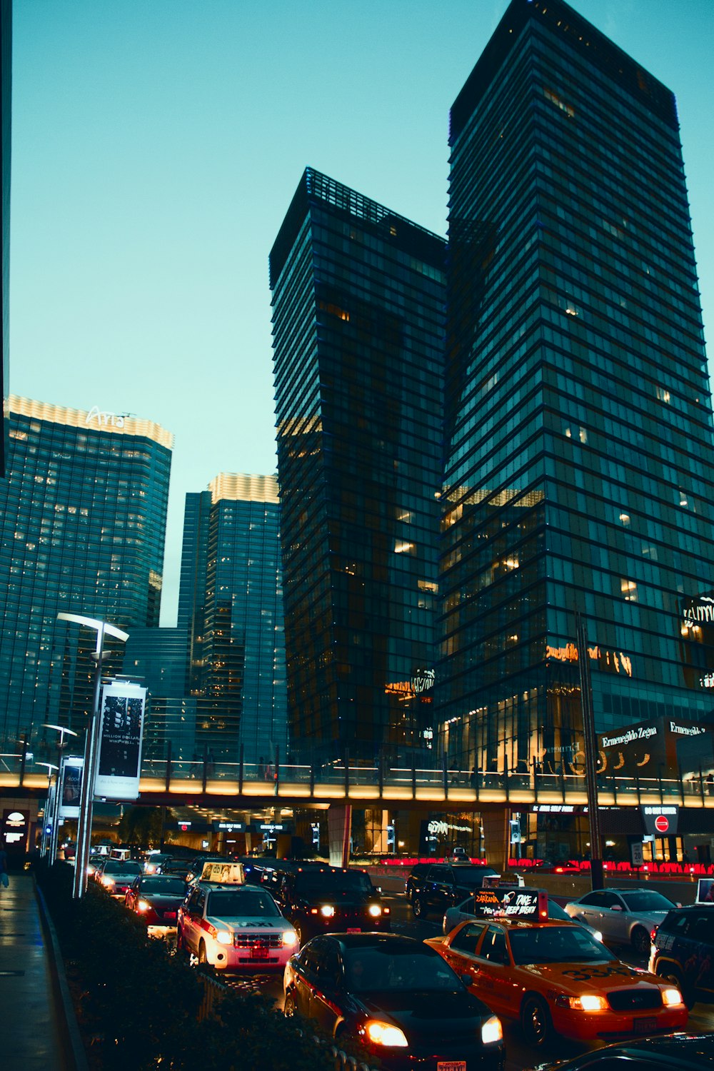 a city street filled with lots of traffic next to tall buildings