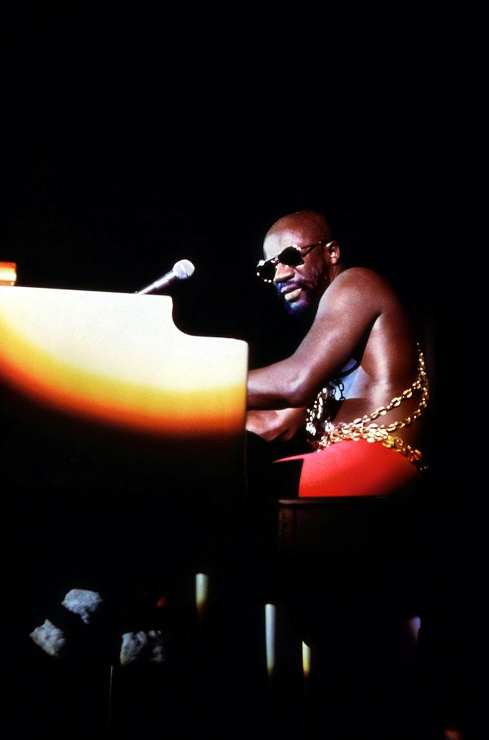 a man sitting at a piano in the dark