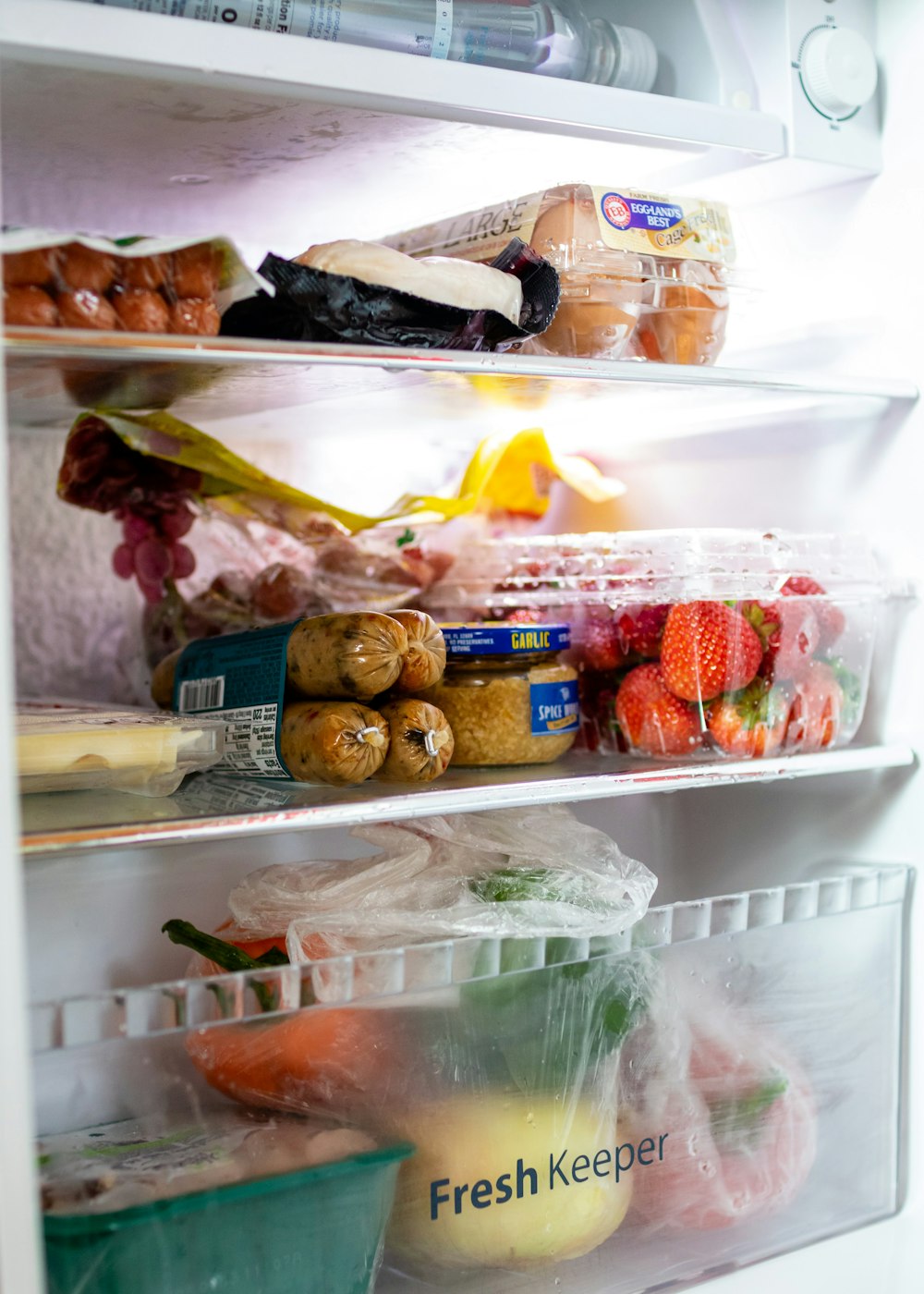 Un refrigerador lleno de mucha comida y bebida