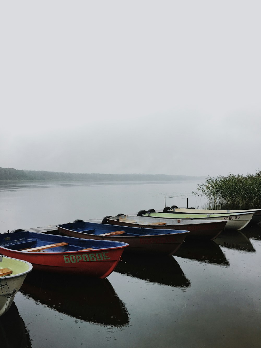 a row of boats sitting on top of a lake