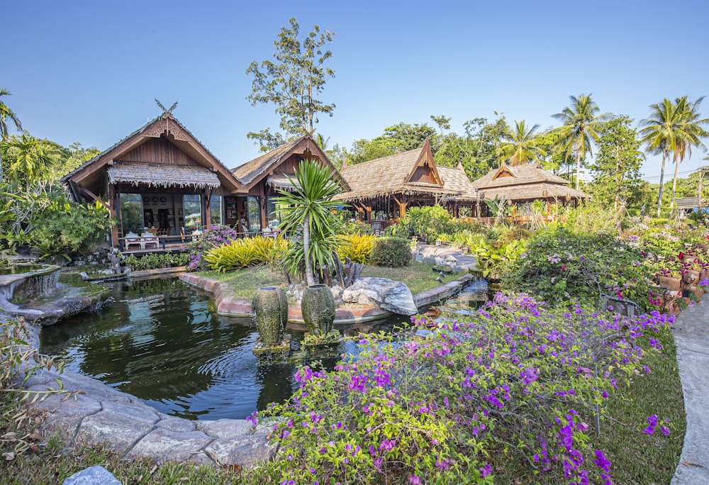 a garden with a pond surrounded by flowers