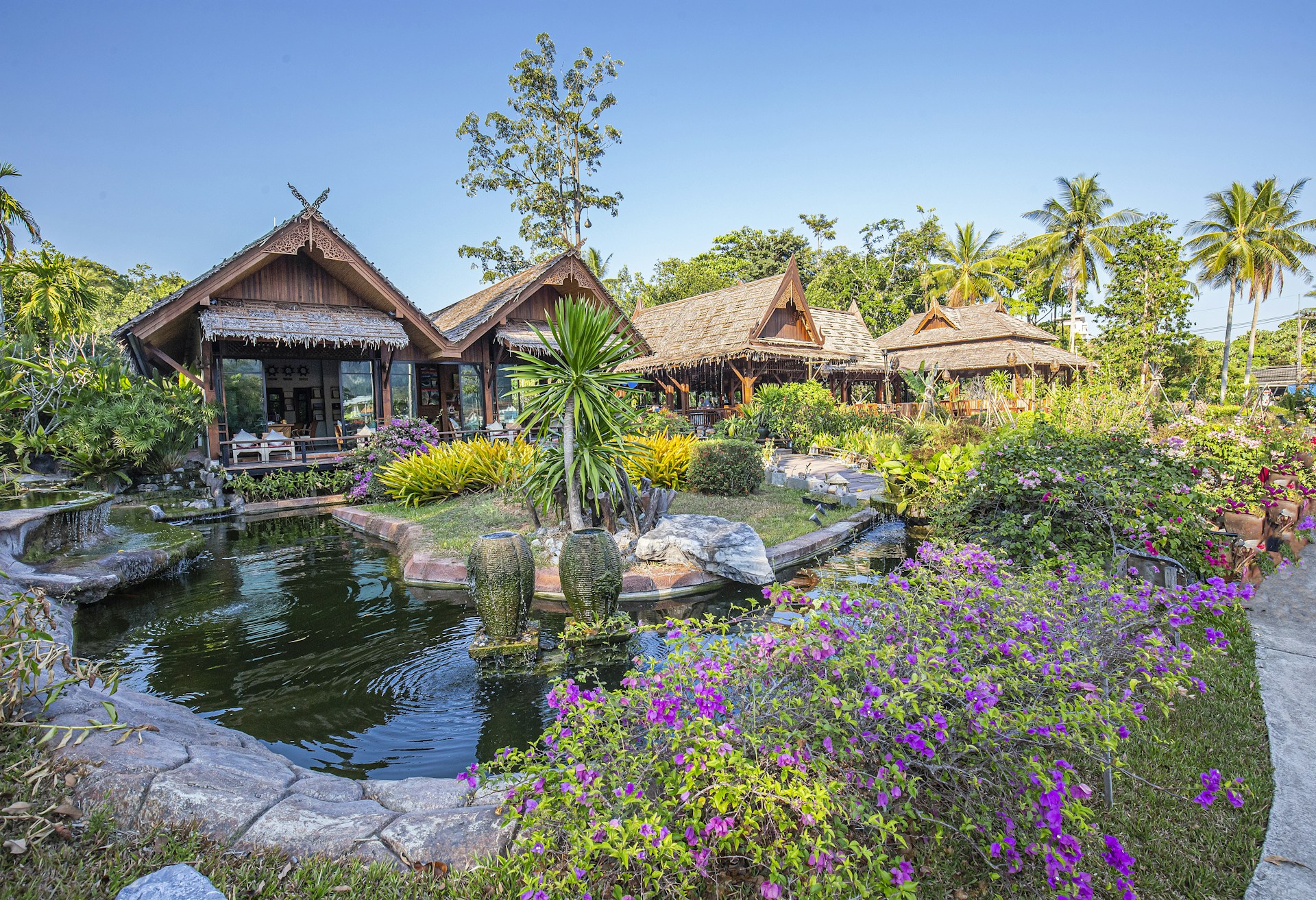 a garden with a pond surrounded by flowers