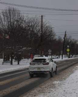 A snowy residential driveway in Surrey, BC, with a professional snow removal truck clearing the path to prevent slips and falls.