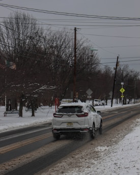 A snowy residential driveway in Surrey, BC, with a professional snow removal truck clearing the path to prevent slips and falls.
