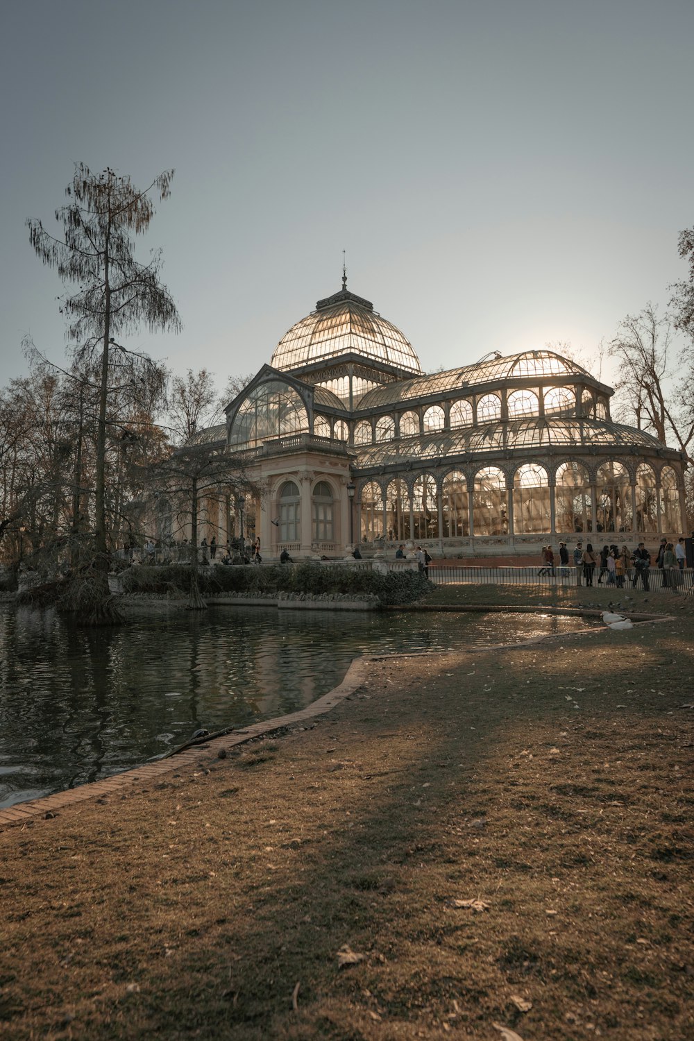 a large glass building sitting next to a body of water