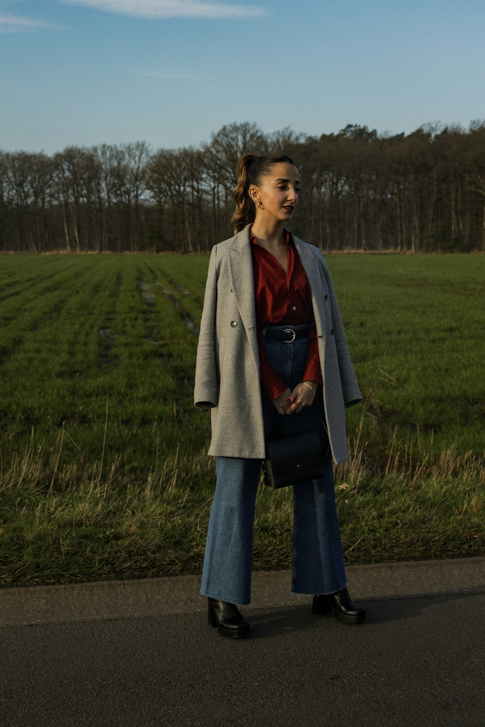 a woman standing on the side of a road