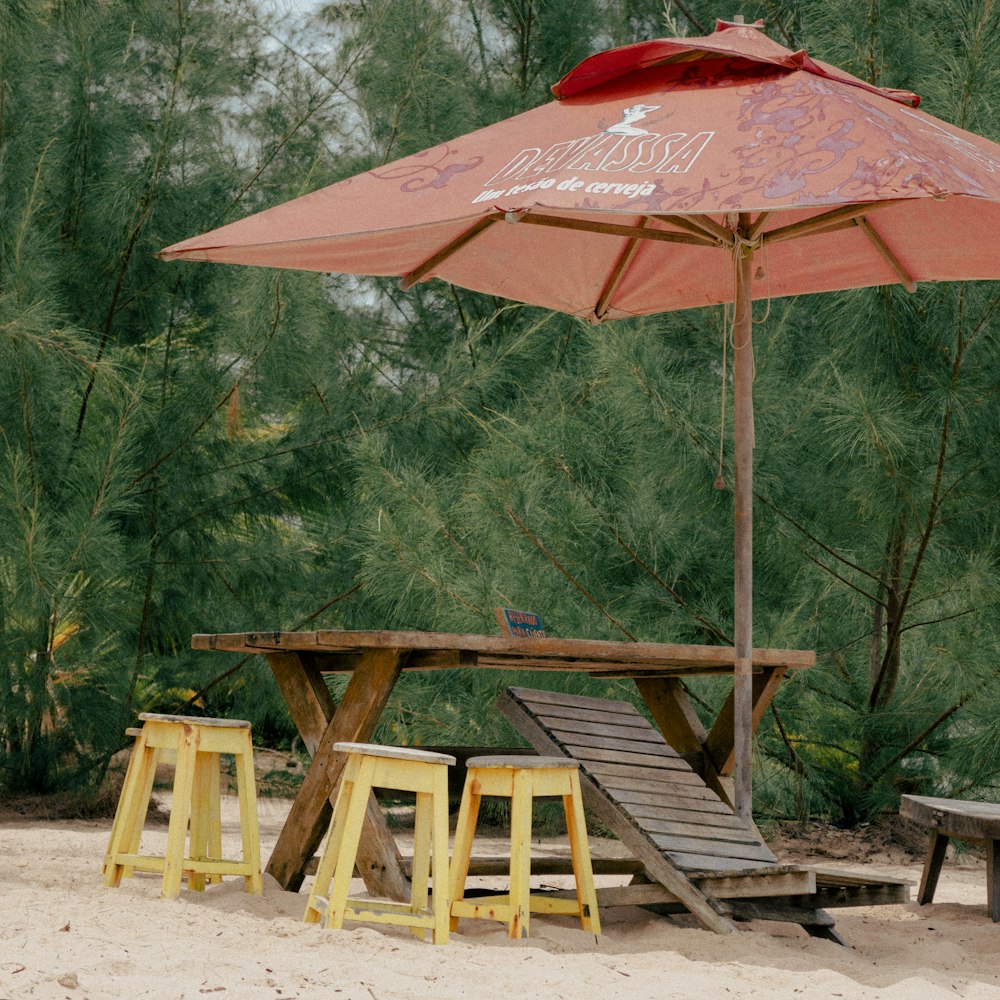 a picnic table with two stools under an umbrella