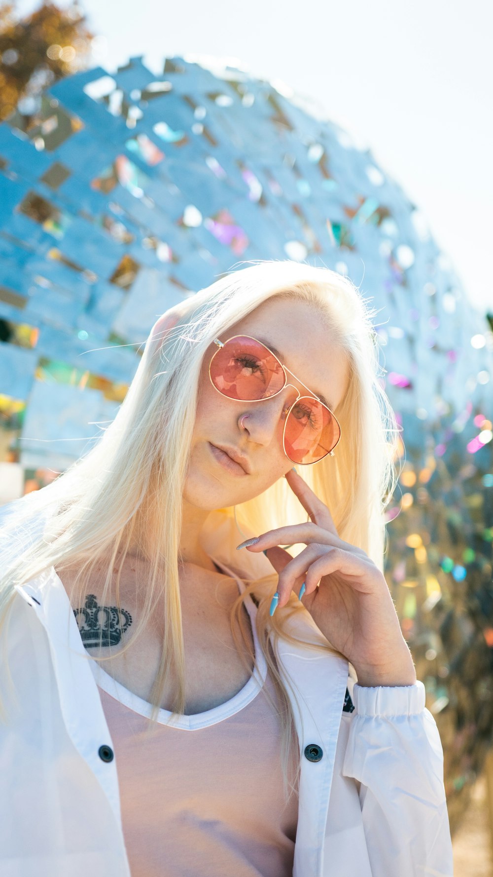a woman with blonde hair and sunglasses posing for a picture