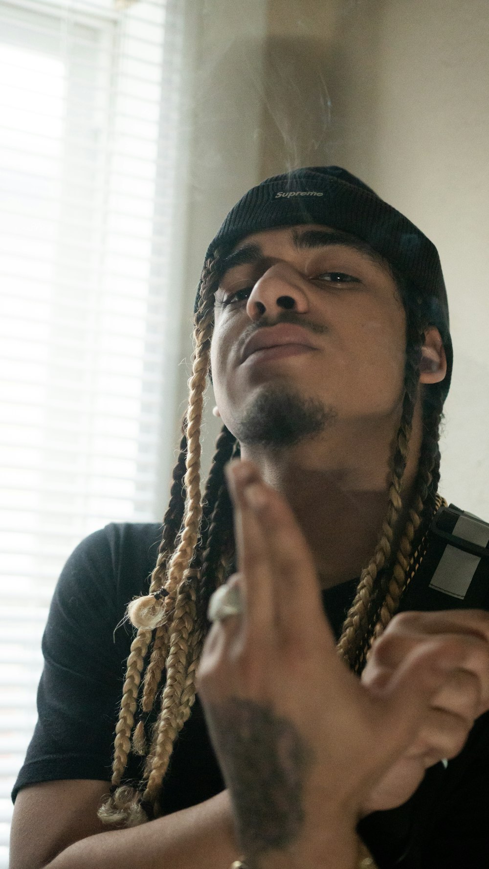 a man with dreadlocks smoking a cigarette