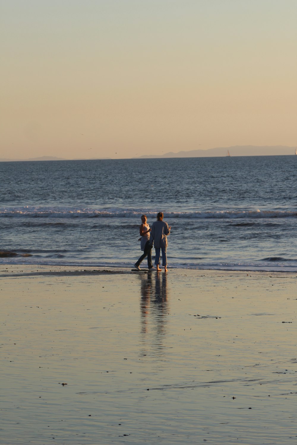 a couple of people standing on top of a beach
