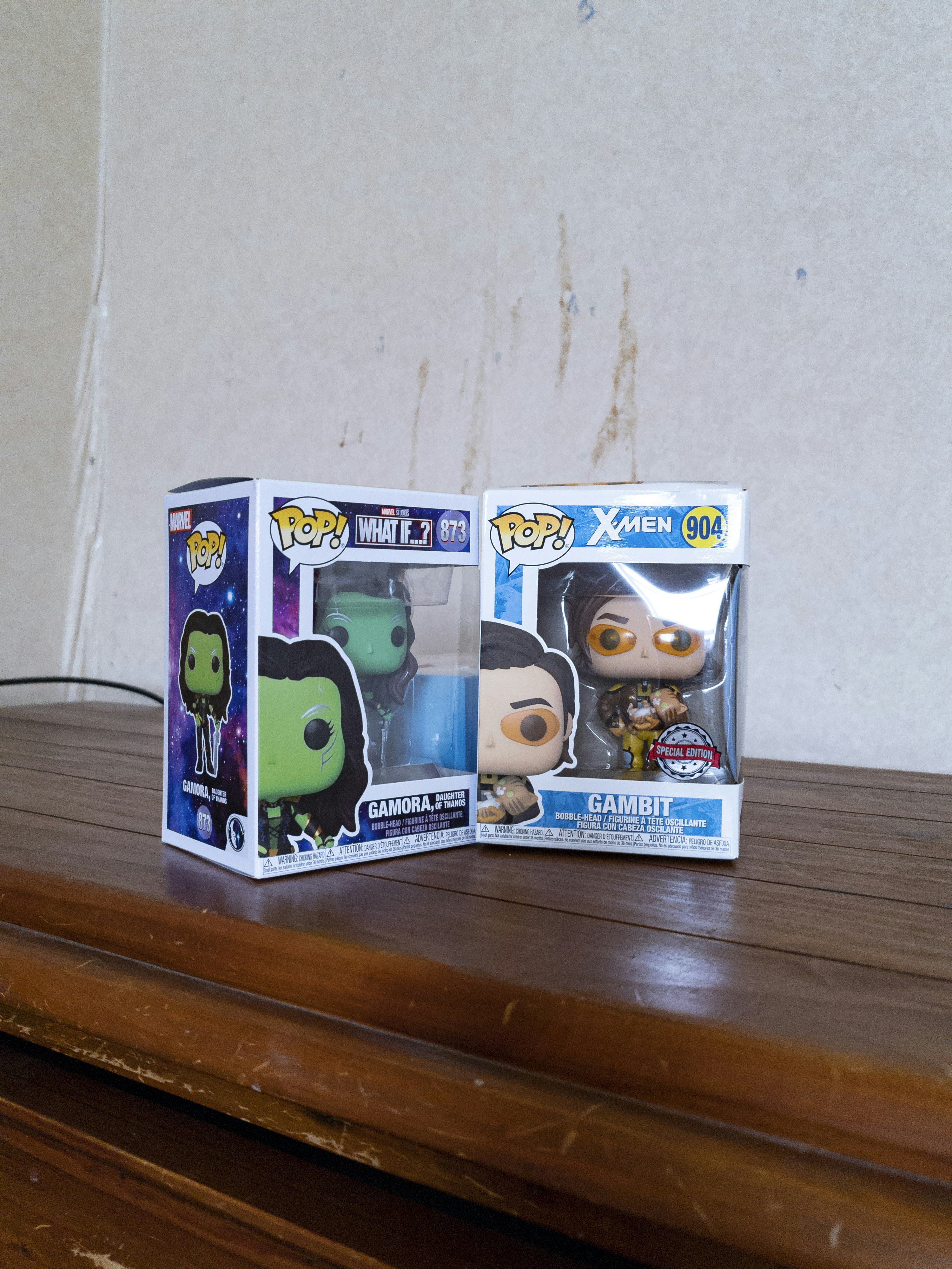 Un paio di figure in vinile pop sedute sopra un tavolo di legno