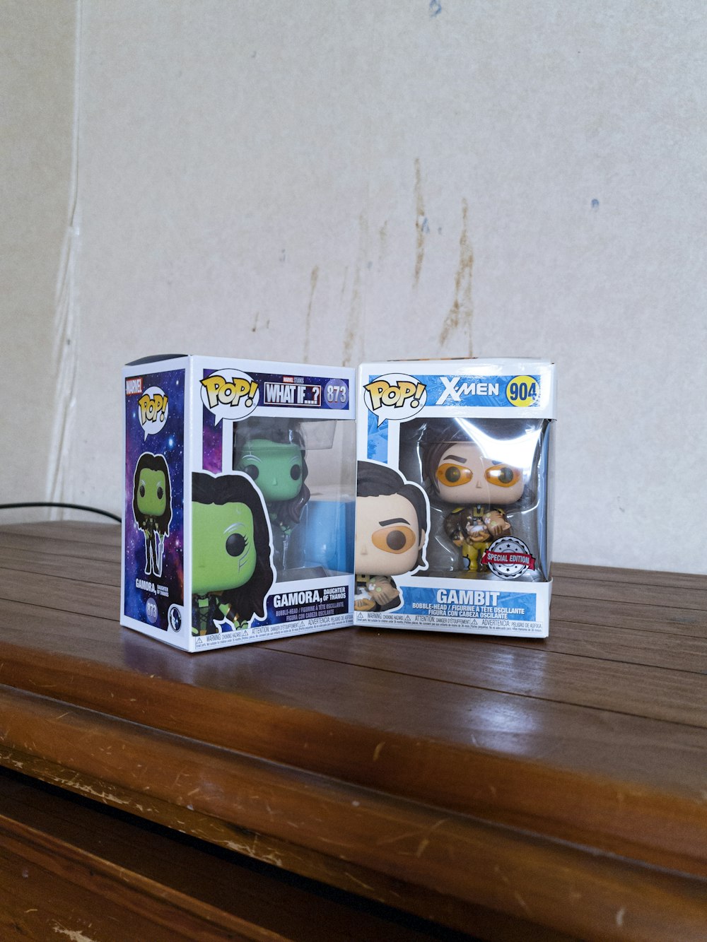 a couple of pop vinyl figures sitting on top of a wooden table