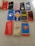 A collection of twelve phone cases displayed on a flat surface. The designs feature various superhero and pop culture symbols, including Spider-Man, Harry Potter glasses and lightning bolt, Marvel logos, and symbols associated with Star Wars and other franchises. The cases are predominantly made of plastic with colorful prints and patterns.