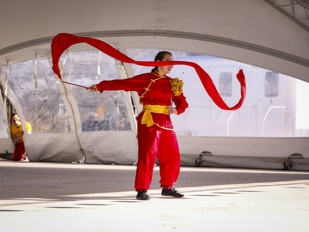 a woman in a red outfit holding a red ribbon