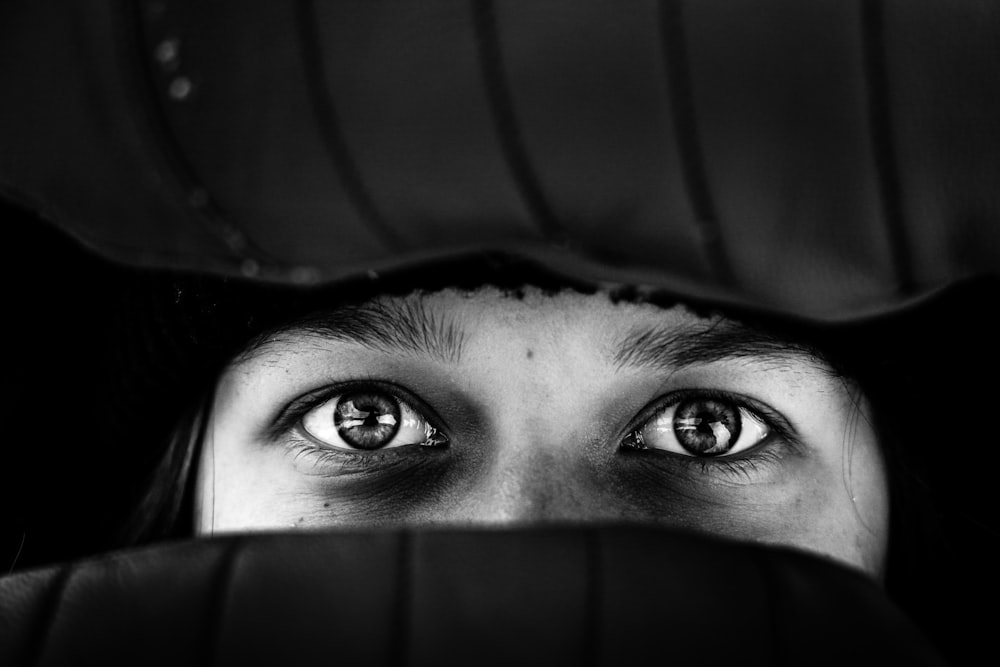 a woman peeking out from behind a chair